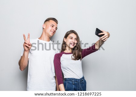 happy young couple taking selfie with smartphone isolated on white