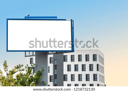 Blank white billboard for advertisement  on the background of modern white building and colorful sky. Sunset.