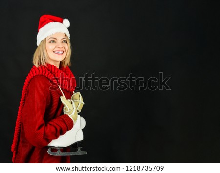 Sport, snow, winter time, healthy lifestyle, leisure concept. Christmas time. Happy beautiful girl with figure skates. Young woman with ice skates for winter ice skating. Female skater with ice skates