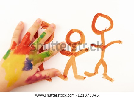 Child's hand covered in paint drawing funny little people