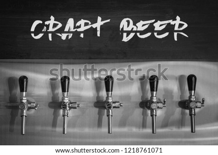 Beer tap in row with hand writing text - Craft Beer - on board in bistro cafe. 