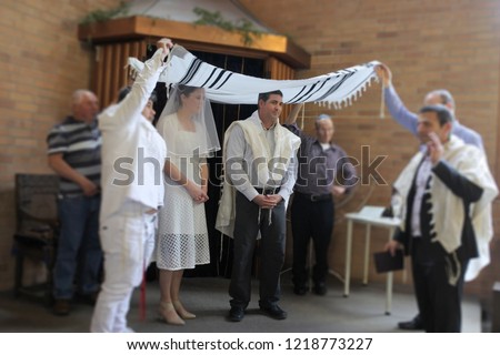 Jewish bride and Jewish bridegroom married in a modern Orthodox Jewish wedding ceremony in a synagogue.Real people. Copy space Royalty-Free Stock Photo #1218773227