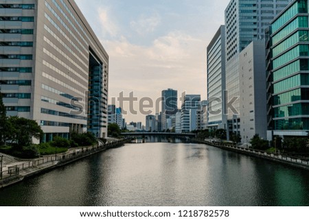 High rise buildings, either side of a river cutting through the city, taken in Tokyo