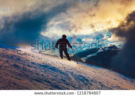 Skier silhouette sunset ride in the mountains
