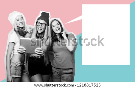 Three girls friends taking selfie with digital tablet, studio shot over gray background