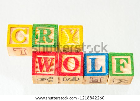 The term cry wolf visually displayed on a white background using colorful wooden toy blocks image with copy space in landscape format