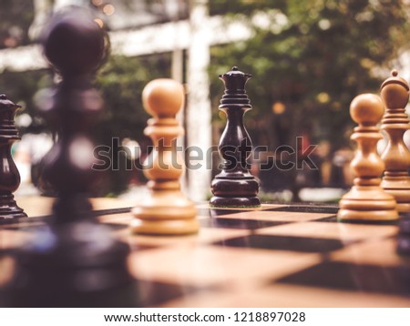 Standing queen black surrounded pawn white chess board play game minion strong stand resist single defeat competition success wooden intelligenc sport power alone set playing little win strategy
