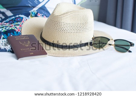 passport, hat, and sunglasses on withe bed, accessories for the trip. soft focus. 
