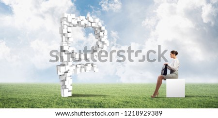 Elegant businesswoman with suitcase in hand sitting on white cube and big rouble sign