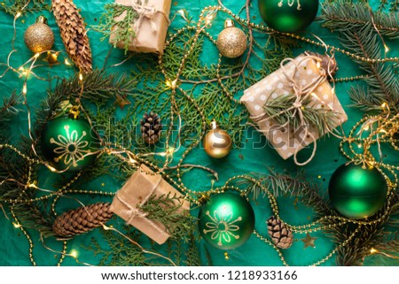 gift boxes on green table and fir branches. box with ribbon bow present on holiday wrapped paper. minimalistic Christmas gifts and balls