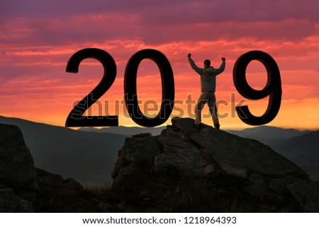 New Year concept, man standing on mountain peak at sunrise