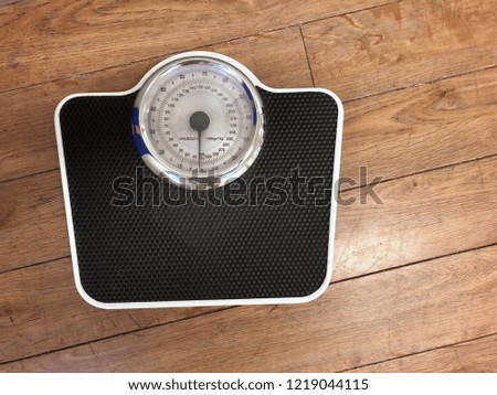 Analog weight scale on a wood floor