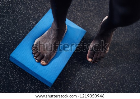 Feet correction and balance exercise. Black man using foam device in a gym. Sport.