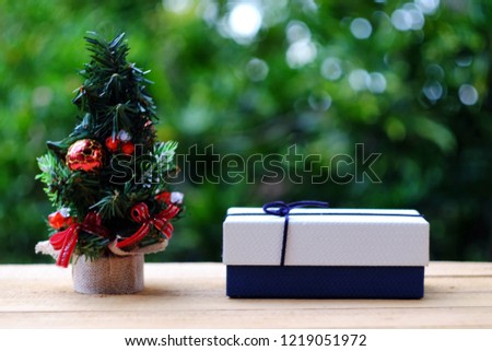 close up toy pine tree and gift box on ild wood table, green nature copy space background for text, merry christmas, happy new year 2019, holiday season business concept 