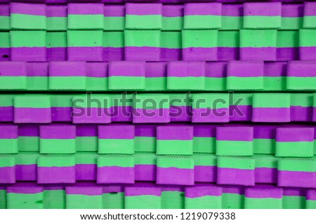 green-violet sports mats stacked in large stack
