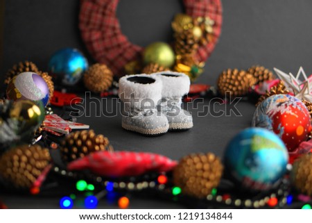 dark surface decorated with Christmas toys and gerland with boots for gifts on the background of a Christmas wreath
