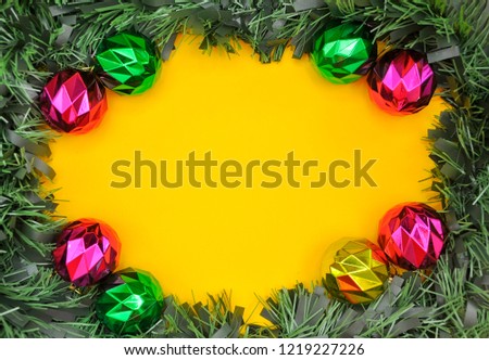 Christmas and New Year background decoration. Frame made of blank concept, pine branches, toys on yellow background. Flat lay, top view.