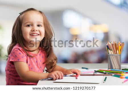 Cute little girl doing homework, reading a book, coloring pages, writing and painting. Children paint. Kids draw. Preschooler with books at home. Preschoolers learn to write and read. Creative toddler Royalty-Free Stock Photo #1219270177
