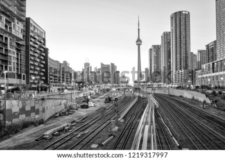A view of Toronto downtown in black and white over the bridge with buildings and train at sunrise