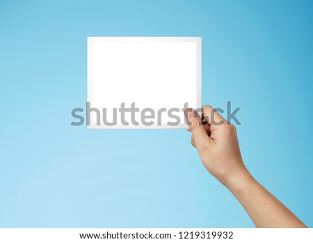 hand holding photo frame. blue. white