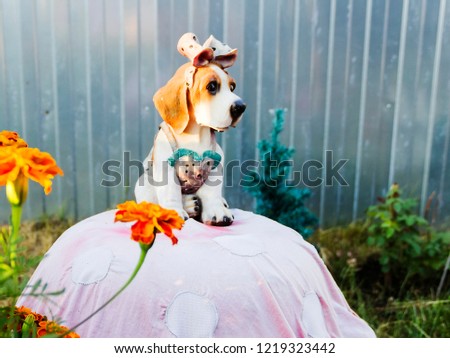 pictured in the photo little beautiful artificial dog to protect the garden