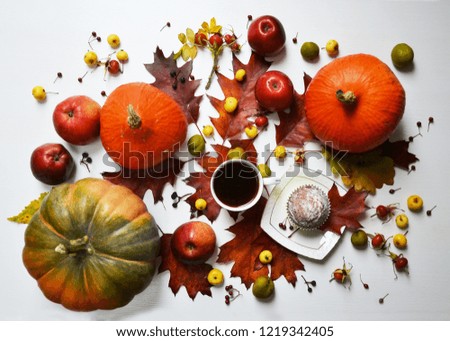Vintage Autumn background with cup of coffee, cupcake, apples, pumpkins, berries and fallen leaves on  white table/Thanksgiving day concept
