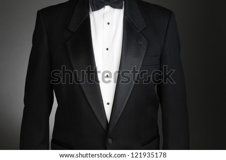 Closeup of a Black Tuxedo Jacket. Torso only on a light to dark gray background. Horizontal format. Royalty-Free Stock Photo #121935178