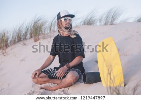 young man on a yellow balance board near the ocean
