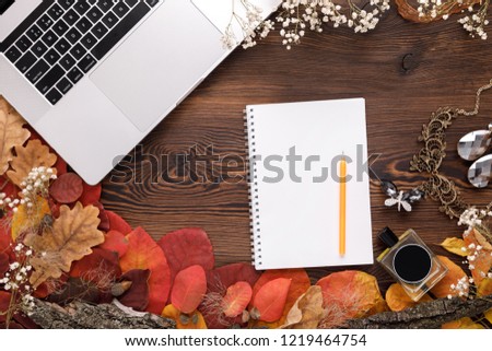 Fashion female accessories Set. autumn leaves, paper notebook and laptop on wooden background with copy space for text, top view. flat lay