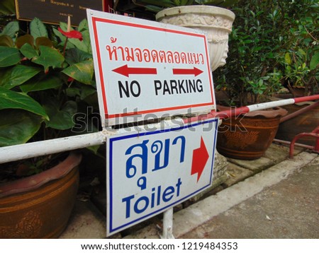 Signs to the toilet and no parking.