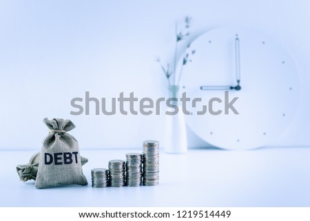 Debt financing  bad, unsecured consumer debt, financial concept : Debt bags, stacks of coins on a table, depicts rising in total interest expense a borrower should repay to a lender when paying late Royalty-Free Stock Photo #1219514449