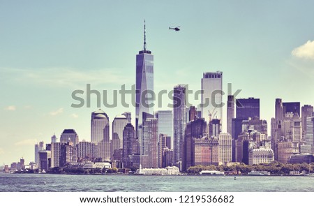 Retro toned picture of downtown New York skyline with hovering helicopter, USA.