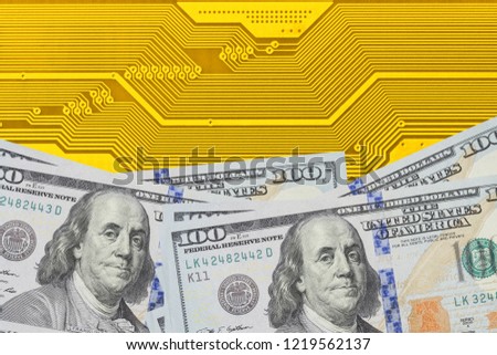 Conceptual image of power in digital and financial industry. Stack of dollar bills on electronic circuit board close up. Background can use the Internet, print advertising and design