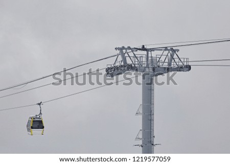 Cable car on a background of clouds, close-up. Cabs for the transport of tourists in a winter ski resort.