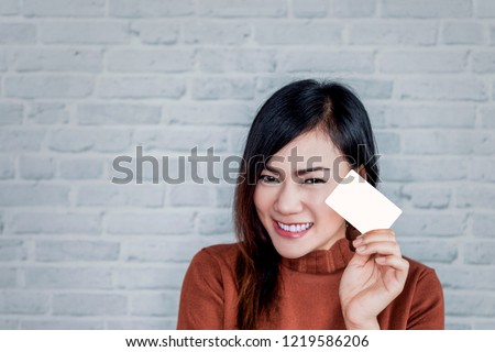 picture of Asian girl smiles as she holds the card.