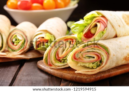 Tortilla wraps with with lettuce, ham and cheese sliced in half, healthy lunch snack