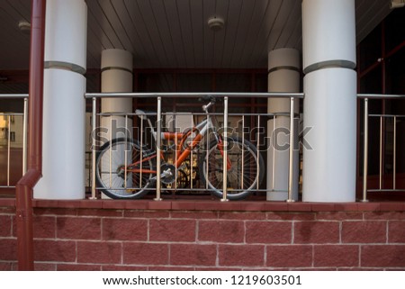 the bike is parked in the gleaming railing of a modern building