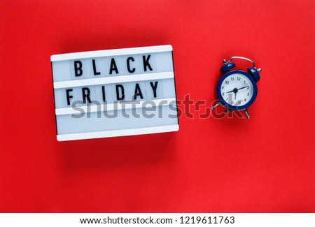Creative flat lay composition sale text on lightbox, blue alarm clock on red background with copy space. Template Cyber Monday sale mockup 