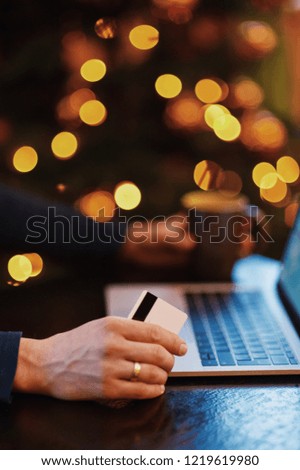 Close-Up Of Laptop By Flower Vase On Table Against Illuminated Lights. Close-Up Of Man Holding Coffee By Laptop On Table. Cropped Hands Of Man Using Laptop At Table. Man Holding Credit Card 