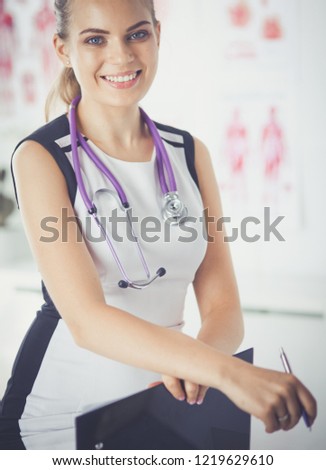 Close up Portrait of friendly female doctor with stethoscope and tablet in hands.