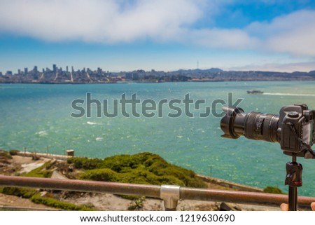 Sea view from Alcatraz island of camera taking pictures of the San Francisco Financial District skyline in California, United States.