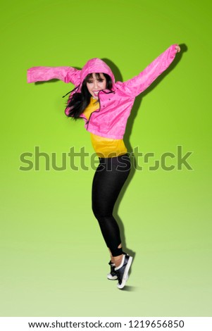 Portrait of Asian woman doing hip hop dance in the studio with green screen