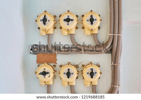Electric switches on a white plastered wall with connected cables.