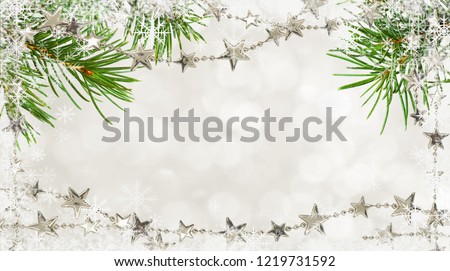 Christmas garlands with stars and pine twigs on holiday background with snowflakes