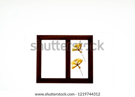 Isolated brown picture frame against white background. One side contains dried red orange flower. Can be personalized by inserting pictures of people and objects.