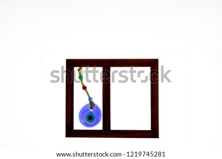 Isolated brown picture frame against white background. One side contains evil eye masallah pendant. Can be personalized by inserting pictures of people and objects.