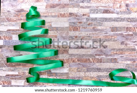 Christmas decoration over a stone wall background, christmas tree ribbon