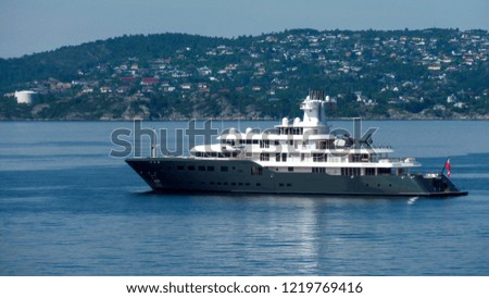 Huge luxury yacht float in the bay with mountain panorama in the background.