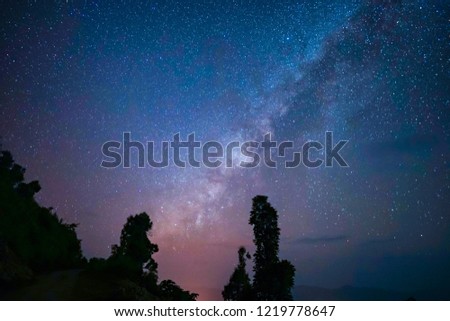 Blurred image,Panorama of Milky way in the dark night over the trees on mountain peak is famous for tourism with noise.