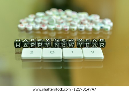 HAPPY NEW YEAR 2019 written with Acrylic Black cube with white Alphabet Beads on the Glass Background